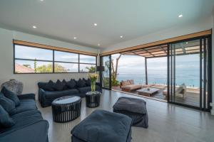 Villa Namaskar - Iconic 5BR Cliff Top Villa - 180° Ocean View في جيمباران: غرفة معيشة مع كنب وإطلالة على المحيط +146 صورة