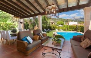 une terrasse avec un canapé et des chaises ainsi qu'une piscine dans l'établissement Ferienhaus in Mancor De La Vall mit Terrasse und Garten und Bergblick, à Mancor del Valle