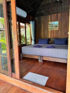 Cama dentro de una habitación con ventana en Huay Kub Kab the Villa, en Ban Muang Kut