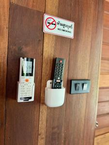 una puerta con una señal de no fumar y controles remotos en Huay Kub Kab the Villa, en Ban Muang Kut
