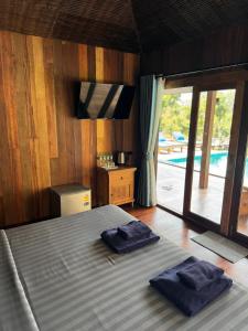 Un dormitorio con una cama con dos toallas encima. en Huay Kub Kab the Villa, en Ban Muang Kut