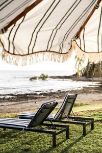 two lounge chairs on the beach under a tent at Seaspray Yeppoon in Yeppoon