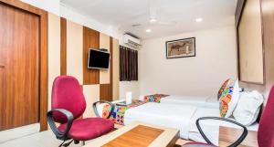 a bedroom with a white bed and pink chairs at Hotel Park Resort Bhubaneswar Couple Friendly in Bhubaneshwar