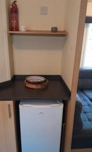 a small kitchen with a white refrigerator and a counter at Cosy holiday home stay in Great Clacton