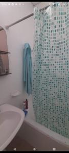 y baño con ducha y toalla azul. en Lela colonia en Colonia Las Rosas