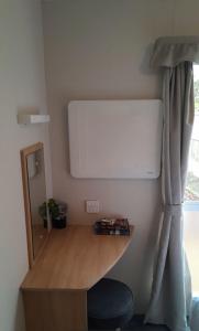 a room with a desk and a bed with a mirror at Cosy holiday home stay in Great Clacton +2 photos