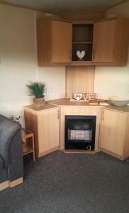 a small kitchen with a stove and a microwave at Cosy holiday home stay in Great Clacton