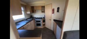 a small kitchen with a sink and a stove at Cosy holiday home stay in Great Clacton