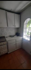 una cocina con armarios blancos y una ventana en Lela colonia en Colonia Las Rosas