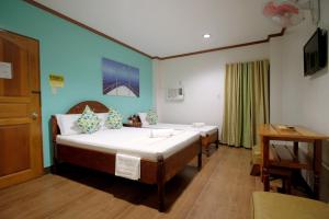 een slaapkamer met 2 bedden en een bureau. bij ISLANDS VIEW INN in Coron