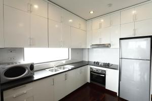 a white kitchen with a sink and a refrigerator at Davidduc's Service Apartment - Xom Chua in Hanoi