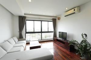 a living room with a white couch and a tv at Davidduc's Service Apartment - Xom Chua in Hanoi