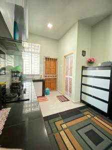 a living room with a kitchen with a large door at HOMESTAY ACIK in Kampong Tanjong Gelam +21 photos