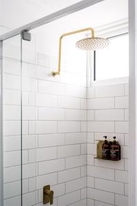 a bathroom with white subway tiles and a glass shower at Seaspray Yeppoon in Yeppoon