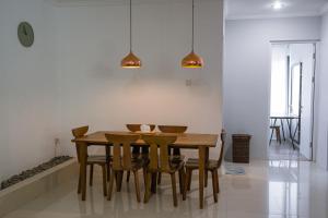 ein Esszimmer mit einem Holztisch und Stühlen in der Unterkunft Brownies House in Bandung