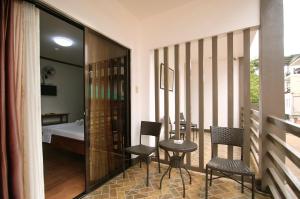 een kamer met een balkon met stoelen en een bed bij ISLANDS VIEW INN in Coron