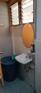 uma casa de banho com um lavatório, um WC e um espelho. em Jorge & Pony House 2 em El Nido