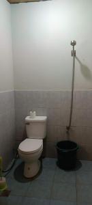 uma casa de banho com WC e um balde preto em Jorge & Pony House 2 em El Nido