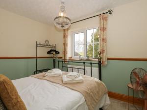 a bedroom with a bed and a window at Coronation Cottage in Wisbech