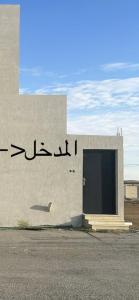 un edificio con una puerta con escritura. en نزل الزلفي لشقق المخدومة, en Az Zulfi