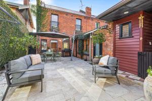 a patio with chairs and a table in a building at 3BR Boutique Villa Walk to SPARK Arena w Parking in Auckland