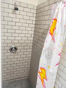 a shower curtain with a superhero design on it in a bathroom at LittleBetty's LandingPad in Torrance