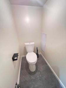 a bathroom with a white toilet in a room at LittleBetty's LandingPad in Torrance