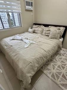 a bed in a bedroom with two people laying on it at Elegant 2 Bedroom Unit @Avida#27 in Iloilo City