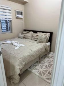 a bedroom with a large bed with white sheets and pillows at Elegant 2 Bedroom Unit @Avida#27 in Iloilo City