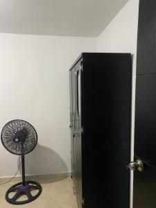 een zwarte koelkast en een ventilator in een kamer bij Festivalvallenatohabitaion in Valledupar