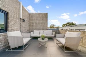 eine Terrasse mit weißen Stühlen und einem Tisch in der Unterkunft King’s Deluxe in Newtown in Sydney