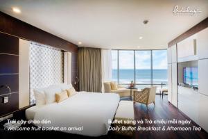 a hotel room with a bed and a view of the ocean at Holiday Beach Hotel Danang in Danang