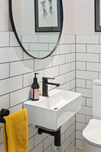 um banheiro branco com uma pia e um espelho em Ocean View Spacious 5BR Retreat for Families em Auckland mais 17 fotografias