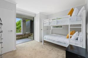 a bedroom with two bunk beds and a doorway at Ocean View Spacious 5BR Retreat for Families in Auckland