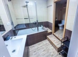 uma casa de banho com uma banheira, um chuveiro e um WC. em La Bendita Apartament - Casc Antic em Tarragona