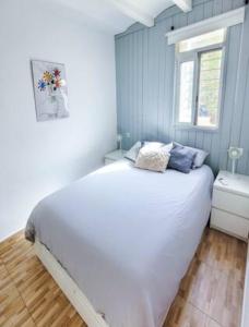 um quarto com uma cama branca e uma janela em La Bendita Apartament - Casc Antic em Tarragona