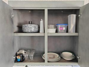 a cupboard with plates and other kitchen items in it at Departamento amplio con hermosa vista in Puebla +9 photos