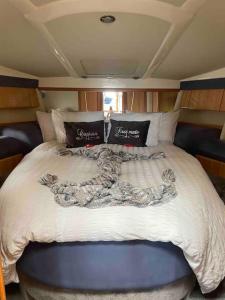 a large bed in the back of a boat at ENTIRE LUXURY MOTOR YACHT 70sqm - Oyster Fund - 2 double bedrooms both en-suite - HEATING sleeps up to 4 people - moored on our Private Island - Legoland 8min WINDSOR THORPE PARK 8min ASCOT RACES Heathrow WENTWORTH LONDON Lapland UK Royal Holloway in Egham