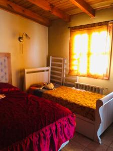 1 dormitorio con 2 camas y ventana en Las Caléndulas en Ushuaia
