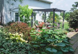 a garden in front of a house with a pergola at Orchard House Bed and Breakfast in Granville