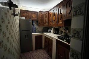 a small kitchen with wooden cabinets and a refrigerator at Casttle Atocha in Amatitlán