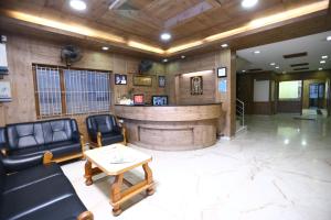 a lobby with a bar with leather chairs and a table at WESTLAND HOTEL- ERODE in Erode