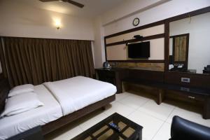 a hotel room with a bed and a television at WESTLAND HOTEL- ERODE in Erode