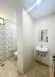 a white bathroom with a sink and a toilet at Roomshala 168 Starlight Suites - Near Max Hospital in New Delhi