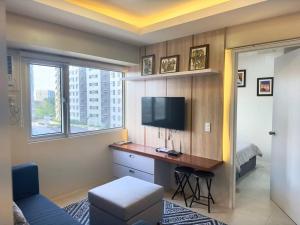 a room with a desk with a television and a bed at Stay comfy & feel Homealike #32 in Iloilo City