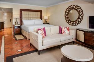 The House by Elegant Hotels - All-Inclusive, Adults Only في سانت جيمس: غرفة نوم بسرير واريكة ومرآة