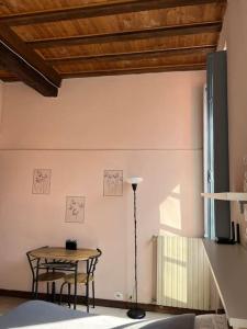 uma sala de jantar com uma mesa e um candeeiro em Minimal Studio con travi a vista em Piacenza