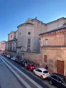 um edifício com carros estacionados ao lado de uma rua em Minimal Studio con travi a vista em Piacenza