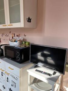 uma televisão numa mesa numa cozinha com um micro-ondas em Minimal Studio con travi a vista em Piacenza