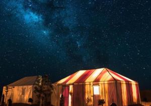 a large tent under a starry sky at night at Amazing Luxury Camp in Merzouga
